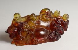 A CHINESE CARVED AMBER GROUND BUDDHA 8ins long
