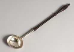 A GEORGE II PUNCH LADLE with plain bow and turned wood handle 14ins long London 1728 maker J.C..