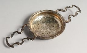 A GEORGE III TWO HANDLED LEMON STRAINER. London 1760, maker Edward Aldridge & Co.