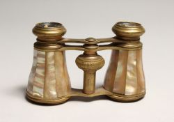 A PAIR OF MOTHER OF PEARL AND GILT OPERA GLASSES 4ins long in a leather case.