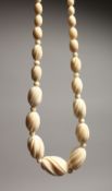 A DELICATE CARVED GRADUATED IVORY NECKLACE of forty one beads 14ins long.