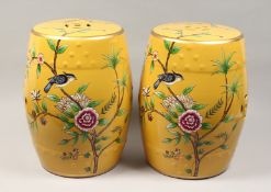 A PAIR OF CHINESE PORCELAIN BARREL SEATS, yellow ground, painted with birds. 17ins high.