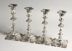 A GOOD SET OF FOUR GEORGIAN STYLE CANDLESTICKS on a leaded base 24cms high Birmingham 1904, Maker I.