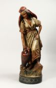 A GOOD LARGE TERRACOTTA FIGURE OF A YOUNG ARAB GIRL carrying a two handled vase, on a circular
