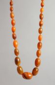 AN AMBER TYPE BEAD NECKLACE with forty six graduated beads