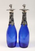 A PAIR OF BRISTOL BLUE DECANTERS with plated fruiting vines.