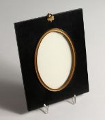 AN EBONISED AND GILT METAL MOUNTED OVAL FRAME, Aperture size 6ins x 4ins