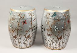 A PAIR OF CHINESE PORCELAIN BARREL SEATS, silver ground, painted with butterflies. 17ins high.