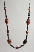 A RHINO BEAD NECKLACE with eight various beads and facet glass beads.