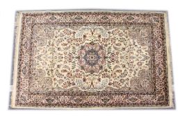 A KASHMIRI WOOL RUG, mid 20th Century, cream ground with floral decoration. 7ft 1in x 4ft 6ins