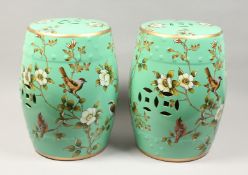 A PAIR OF CHINESE PORCELAIN BARRLEL SEATS, green ground, painted with birds. 17ins high.