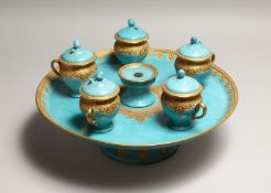 A CONTINENTAL LIGHT BLUE PORCELAIN CIRCULAR TURKISH - ISLAMIC DRINKS SET with gilt decoration,