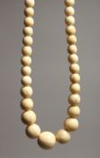 A GOOD GRADUATED IVORY BEAD NECKLACE on ninety beads 28ins long.
