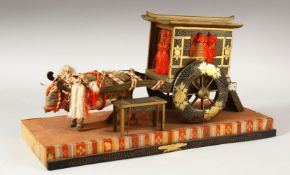 A JAPANESE GILT LACQUER CART AND OX DOLL ON STAND, overall 31.5cm long.