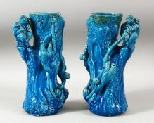 A PAIR OF CHINESE TURQUOISE GLAZED POTTERY MONKEY VASES, the body of each formed as a tree trunk
