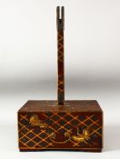 A JAPANESE WOOD AND LACQUER STAND, the base decorated with cranes and gilt latticework, the front