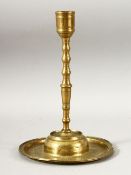 AN 18TH CENTURY OTTOMAN ENGRAVED BRASS CANDLESTICK, the base with a band of calligraphy, 25.5cm.