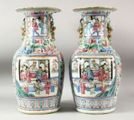 A LARGE PAIR OF CHINESE FAMILLE ROSE TWIN HANDLE VASES, the vases painted with panels depicting