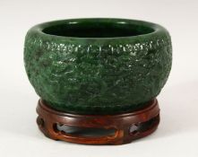 A CHINESE GREEN HARDSTONE BOWL AND STAND, carved with a band of dragons, impressed mark, 16cm