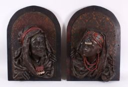 A PAIR OF EGYPTIAN BRONZE RELIEF FIGURAL BUSTS, depicting a prince & princess,each mounted to a