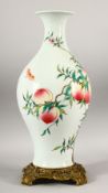 A CHINESE FAMILLE ROSE PORCELAIN PEACH VASE WITH GILT BRONZE STAND - the body of the vase