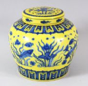 A CHINESE YELLOW GROUND PORCELAIN JAR AND COVER, the painted with fish amongst aquatic flora, 14cm