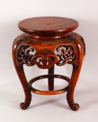 A JAPANESE CARVED HARDWOOD TRIPOD STAND - with a carved frieze of floral form, housing a vase or