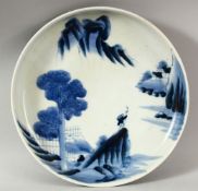 A JAPANESE BLUE AND WHITE PORCELAIN DISH, painted with a figure in a vast landscape, mark to base,