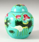 A CHINESE TURQUOISE GLAZED MOULDED VASE AND COVER, the body with cranes and aquatic flora, overall