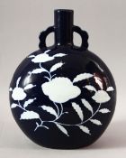 A CHINESE BLUE GLAZED TWIN HANDLE MOONFLASK, the body decorated with flowers in white, 28cm high.