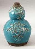 AN UNUSUAL TURQUOISE GLAZED DOUBLE GOURD POTTERY VASE, with moulded decorative motifs, 20cm high.