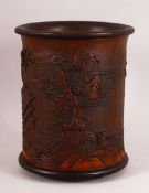 A CHINESE BAMBOO CARVED BRUSH POT - decorated with village landscape scenes, 15cm diameter