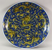 A VERY GOOD CHINESE BLUE AND YELLOW GROUND CHARGER, the centre painted with a dragon and the flaming