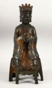 A CHINESE BRONZE SEATED FIGURE, with traces of gilded and painted decoration, 33cm high.