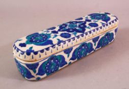 A TURKISH OTTOMAN KUTAHYA POTTERY PEN BOX & COVER, in blue and white floral decoration, 23cm.