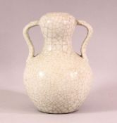 A CHINESE CRACKLE GLAZED PORCELAIN TWIN HANDLE VASE, the base with gilt calligraphy, 19cm high