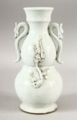 A CHINESE BLANC DE CHINE PORCELAIN TWIN HANDLE VASE - decorated with moulded prunus decoration and