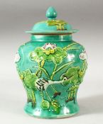 A CHINESE TURQUOISE GLAZED MOULDED JAR AND COVER, the body decorated with cranes amongst aquatic