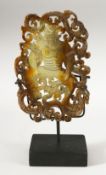 A CHINESE CARVED AND PIERCED HARDSTONE TABLET on stand, the tablet 14cm x 9cm, on stand 18.5cm