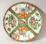 A CHINESE CANTON PORCELAIN PLATE, painted with panels of figures, birds and butterflies, 30.5cm.
