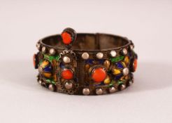 AN 19TH CENTURY MOROCCAN KABIL ENAMELLED SILVER BRACELET, inset with coral beads, 7cm diameter.