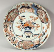 A JAPANESE IMARI / ARITA PORCELAIN DISH, painted with a vase and flowers, the border with lion dogs,