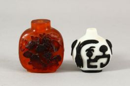 TWO CHINESE SNUFF BOTTLES - one with a white ground with black overlay, the other with carved relief