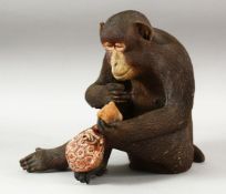 A WELL MODELLED JAPANESE POTTERY FIGURE OF A SEATED MONKEY, 23cm high.