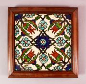 A FRAMED IZNIK STYLE POTTERY TILE SECTION, with a floral motif decoration, 26cm