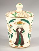 A TURKISH OTTOMAN KATAHYA POTTERY JAR & COVER - decorated with scenes of three figures in landscapes
