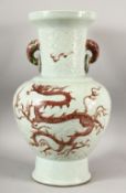 A CHINESE MNIG STYLE CELADON GLAZED CARVED PORCELAIN VASE - decorated with iron red dragons