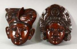 TWO INDONESIAN CARVED HARDWOOD MASKS of a male and female, 27 x 21.5cm and 25cm x 21.5cm.