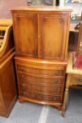 A yew wood narrow chest with a pair of doors over a brushing slide and four long drawers.