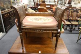 A carved beech window seat with cane work ends and seat.